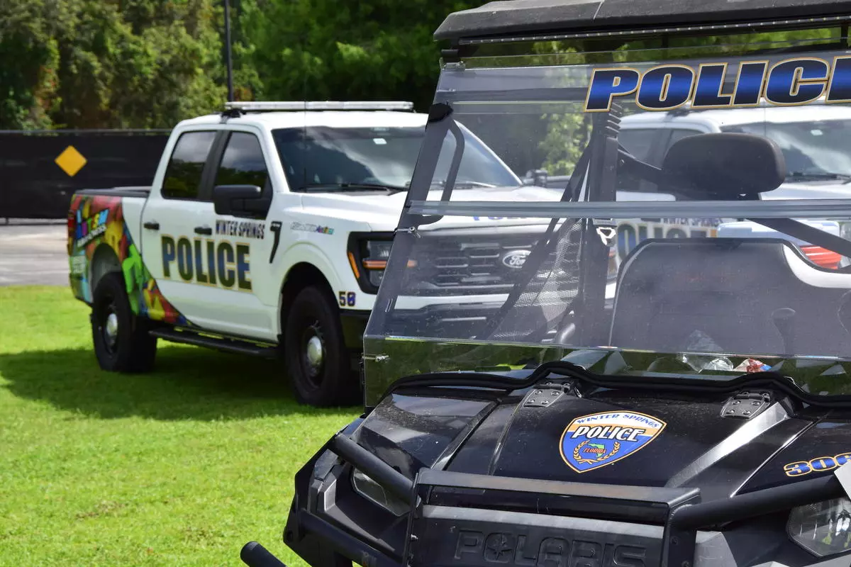 a winter springs police department ATV with a pickup with the autism logo in the background